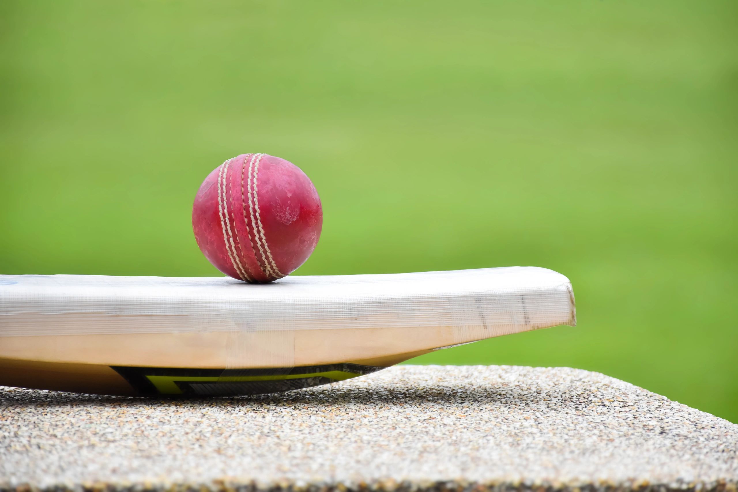 Cricket bat and ball on a hard court