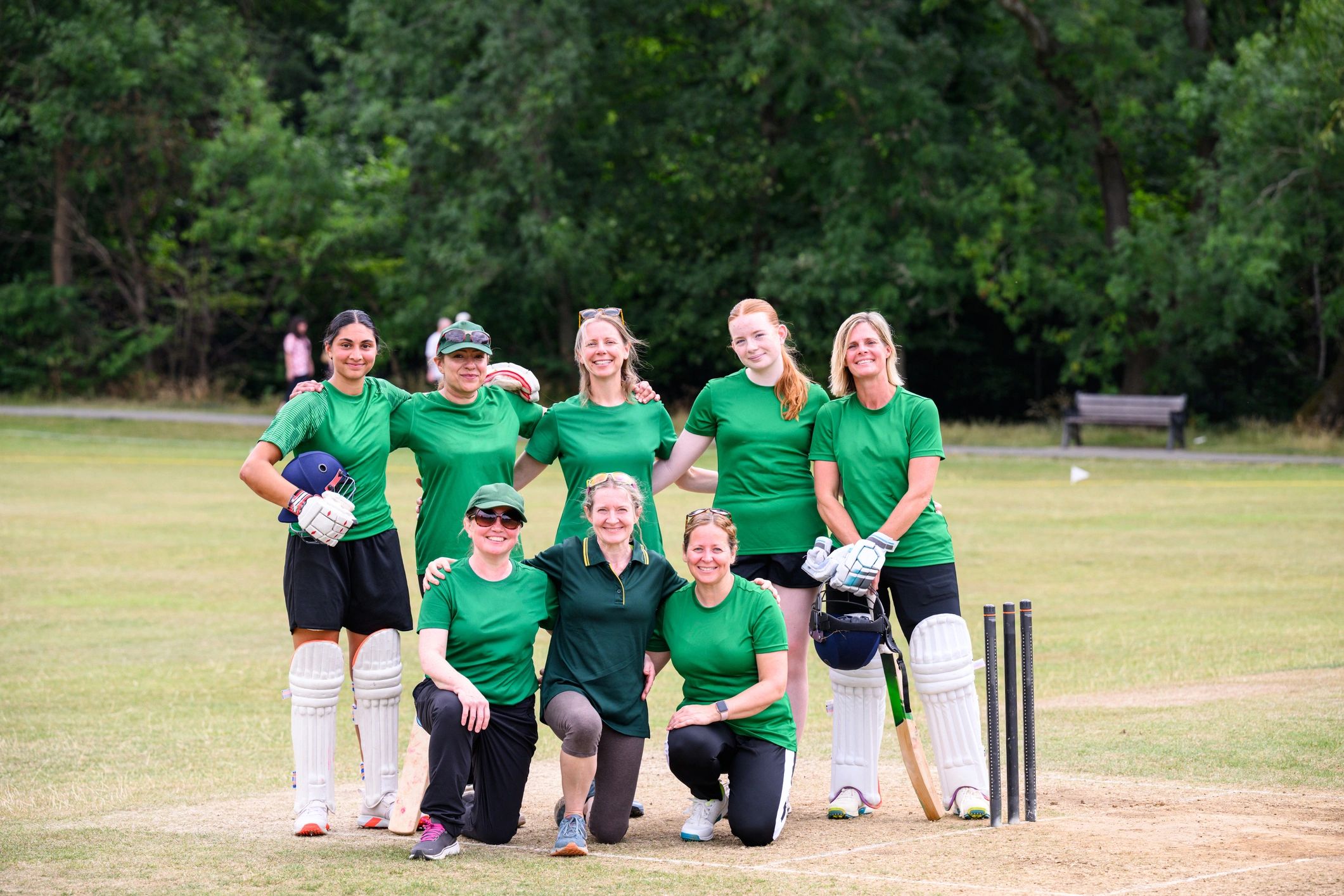 Youth cricket team portrait on a grass pitch