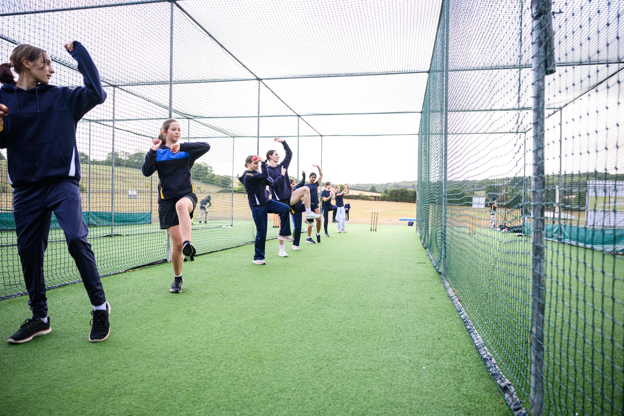 Youth cricket players lined up for bowling practice in nets